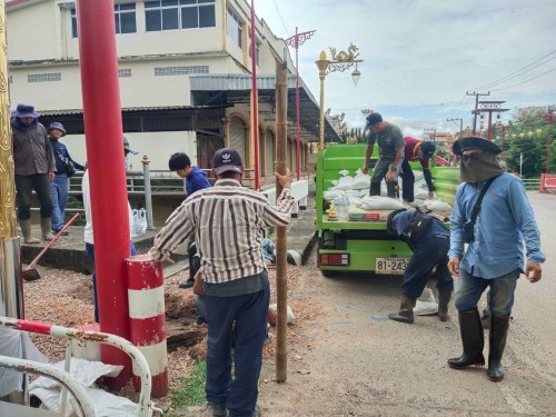 ขุดเปิดหน้างานกระสอบปูนและหินคลุกอุดคอสะพานที่ถูกกัดเซาะ บริเวณสะพานหลังโรงเรียนวัดมณีไพรสารสน